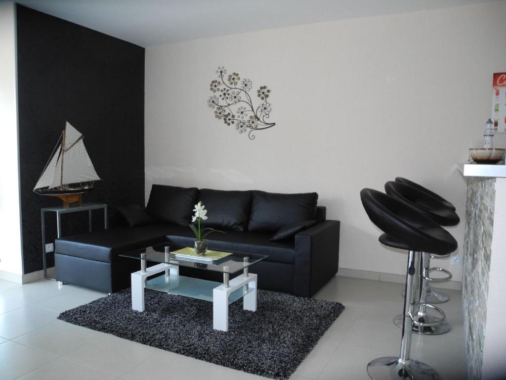 a living room with a black couch and a table at Margaux in De Panne
