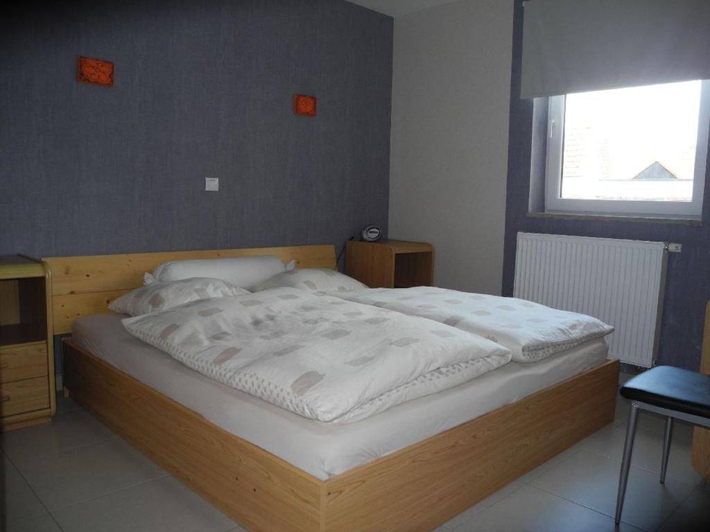 um quarto com uma cama grande e lençóis brancos em Margaux em De Panne