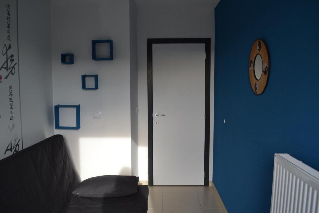 a room with a door and a clock on a wall at Margaux in De Panne