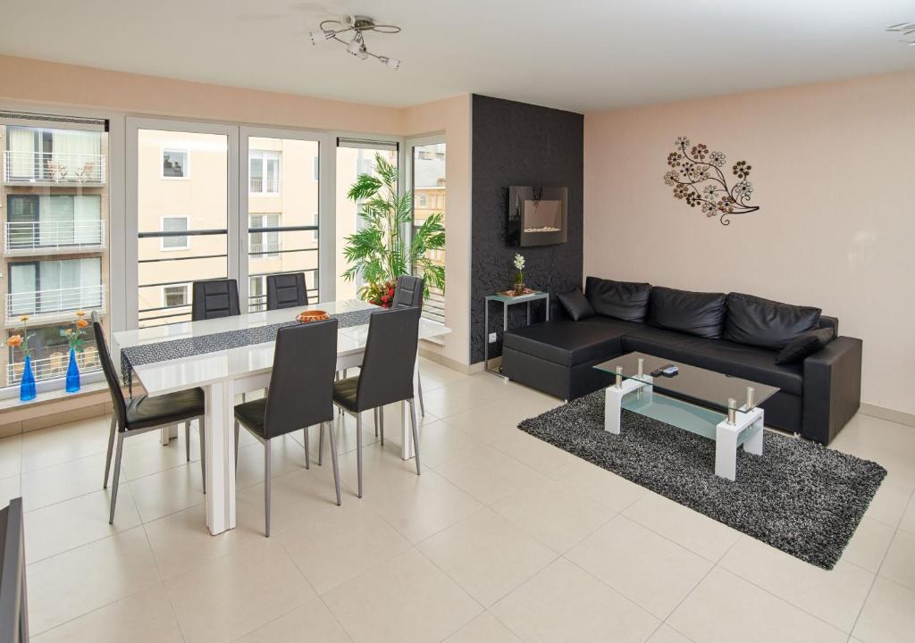 a living room with a black couch and a table at Margaux in De Panne