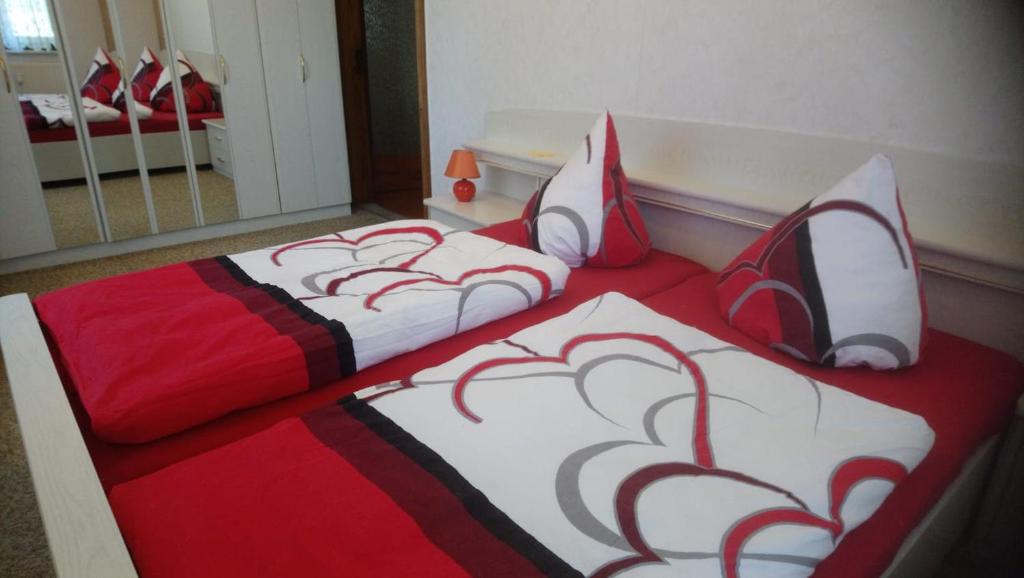 um quarto com 2 camas em vermelho e branco em Ferienwohnung Ehrenfriedersdorf em Ehrenfriedersdorf