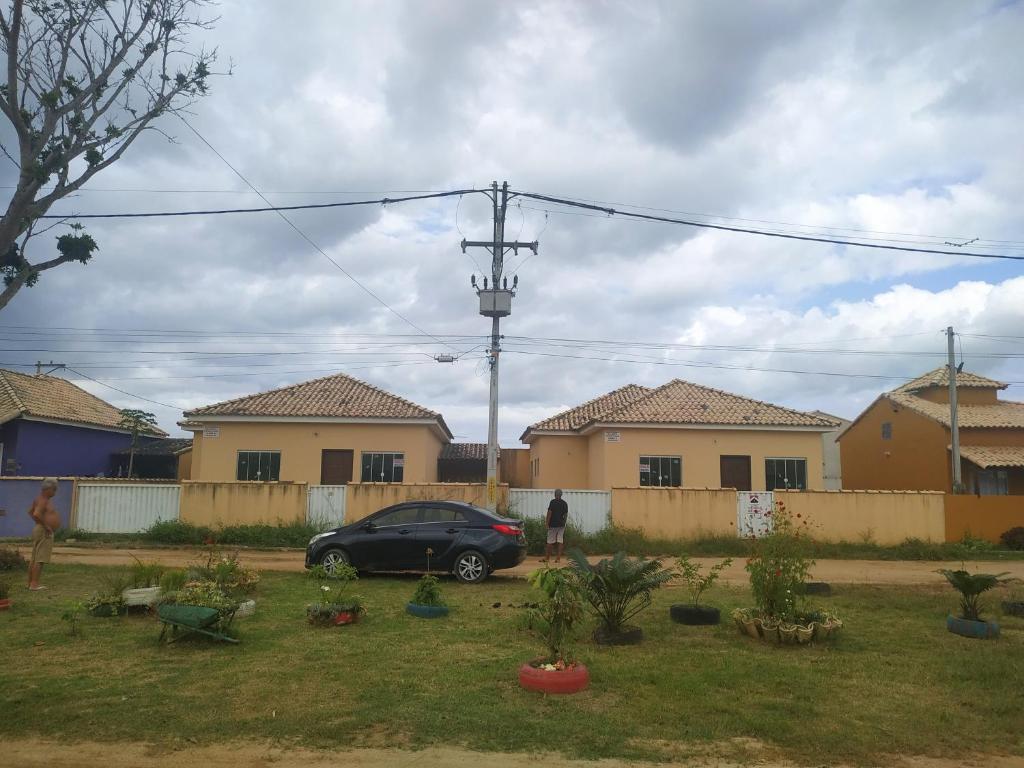 a car parked in a yard with houses at Casa Unamar Cabo Frio/RJ. in Cabo Frio