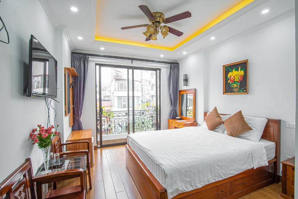 - une chambre avec un lit, un ventilateur de plafond et une fenêtre dans l'établissement Miah Boutique Homestay, à Hanoï