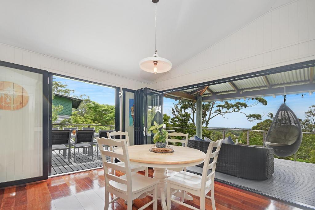a dining room with a table and chairs at Tree Top Oasis in Buderim