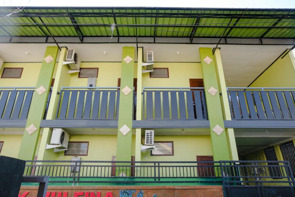 a building with blue balconies on the side of it at Zulfina Homestay Syariah Mitra RedDoorz in Banyuwangi
