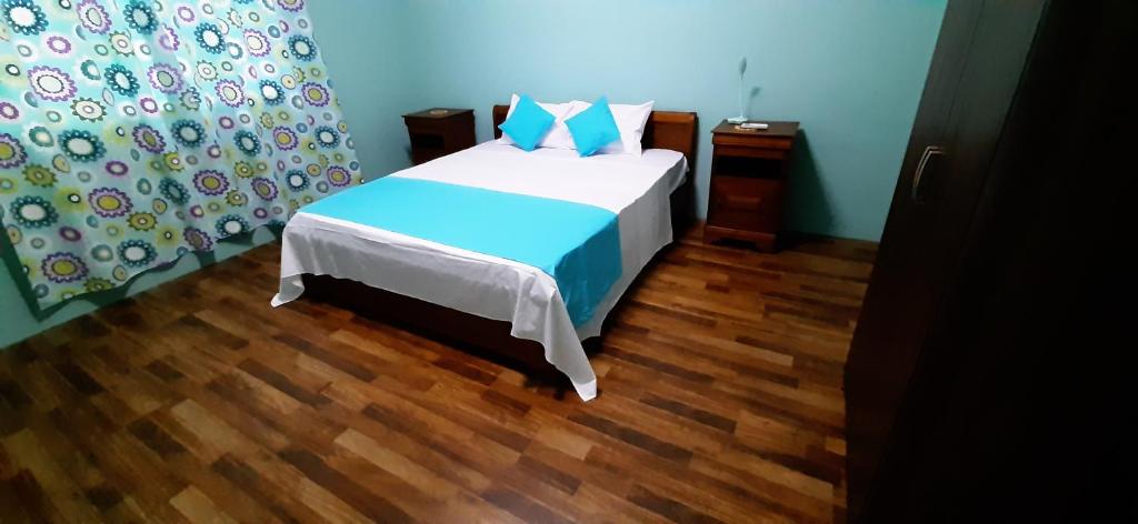 1 dormitorio con 1 cama y suelo de madera en Casa Accacias, en Port Louis