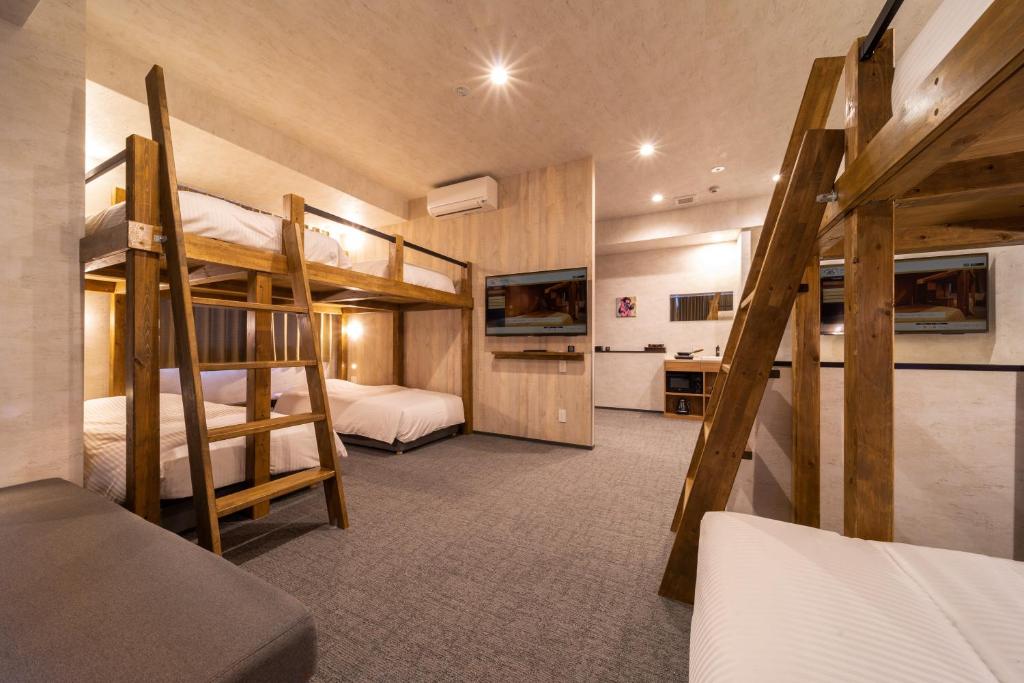 a room with two bunk beds and a bathroom at WELLSTAY Namba in Osaka