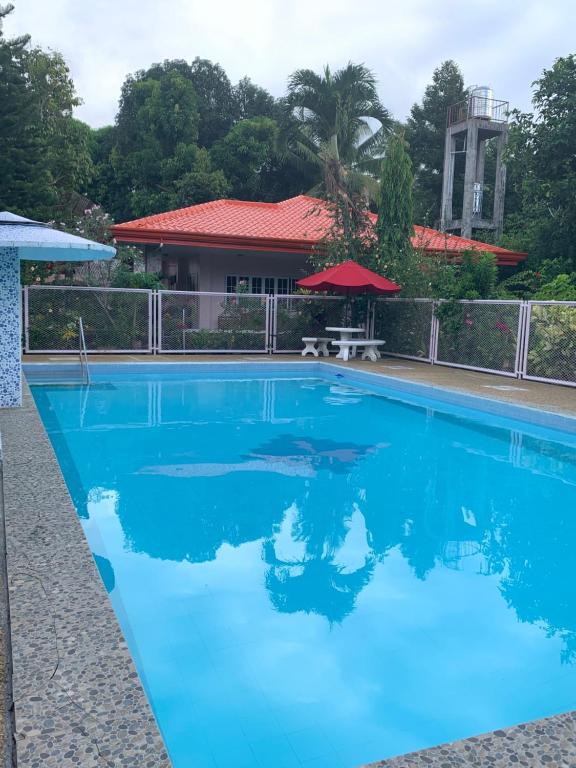 a swimming pool with blue water in front of a house at Powers Holiday vacations in Dipolog
