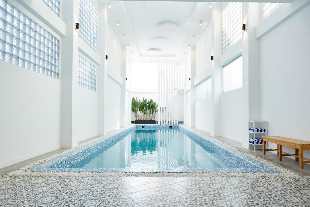 a swimming pool in a building with white walls at 8B Aparthotel in Ho Chi Minh City