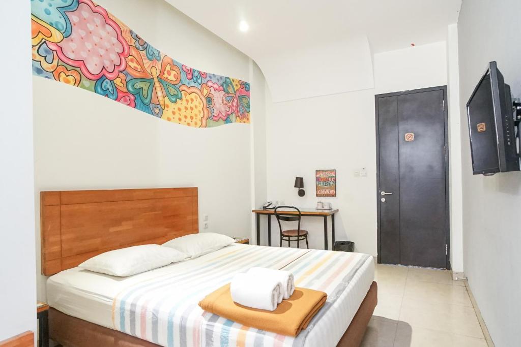 um quarto com uma cama e uma cabeceira em madeira em Istanaku Guesthouse 2 em Manado