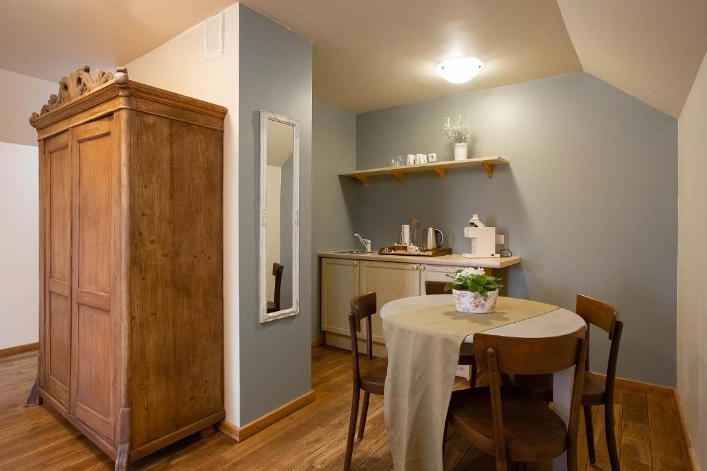 a dining room with a table and a kitchen at Karlamuiza Country Hotel in Kārļi