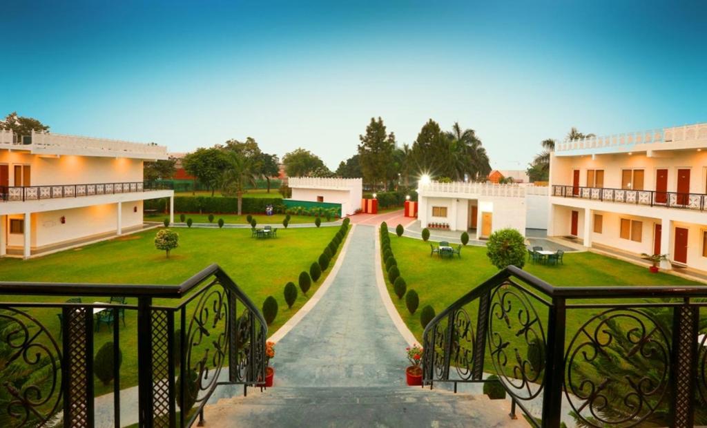 Aapno Ghar Resort & Amusement Park في جورجاون: اطلالة على ساحة مع ممشى بين مبنيين