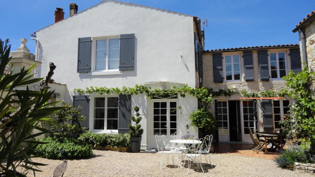 Cette maison blanche dispose de volets noirs et d'une terrasse. dans l'établissement Le Clos des Treilles, à Nuaillé-dʼAunis