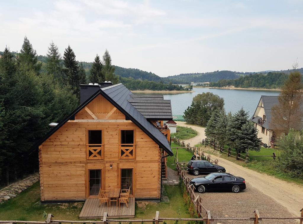 a wooden house with a car parked in front of it at Przystań Bieszczady in Zawóz