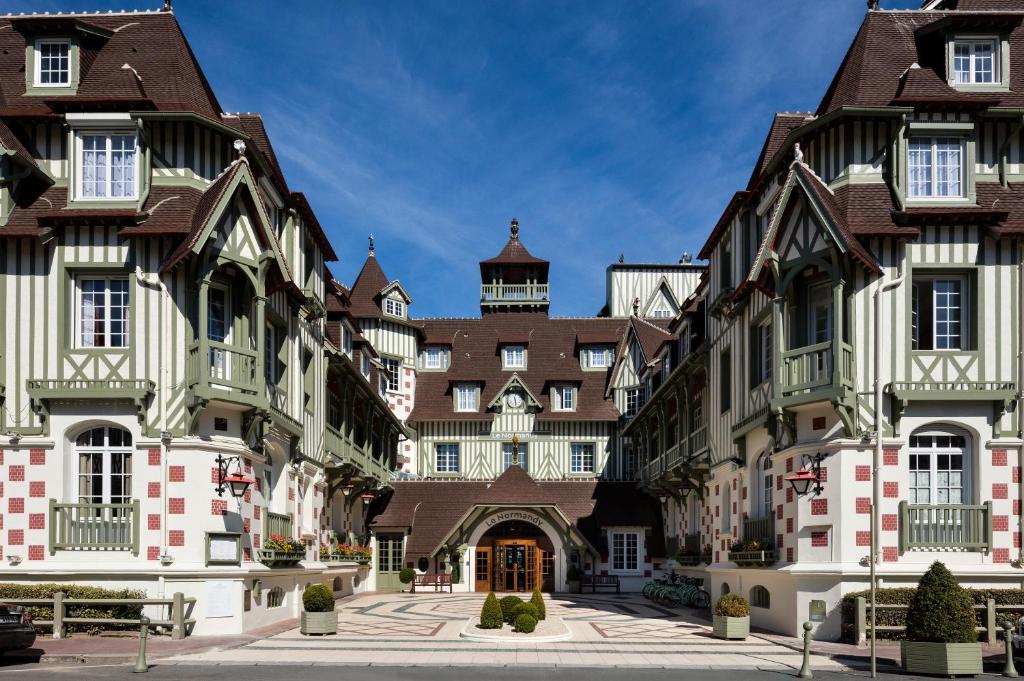 une rangée de bâtiments dans une cour dans l'établissement Hôtel Barrière Le Normandy, à Deauville