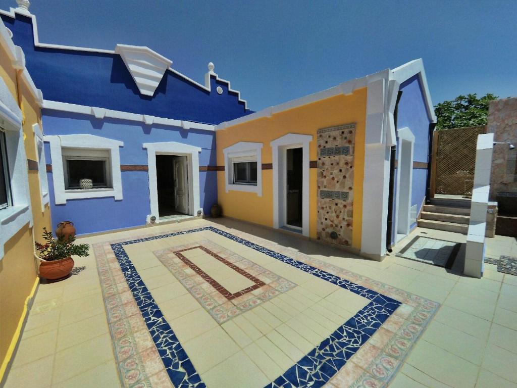 a blue and yellow house with a tile courtyard at Casa DimiGre house in Kattavia - Prasonisi Rhodes in Kattavía