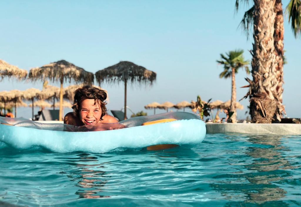 a woman is riding on an infogie board in the water at Mitsis Norida in Kardamaina