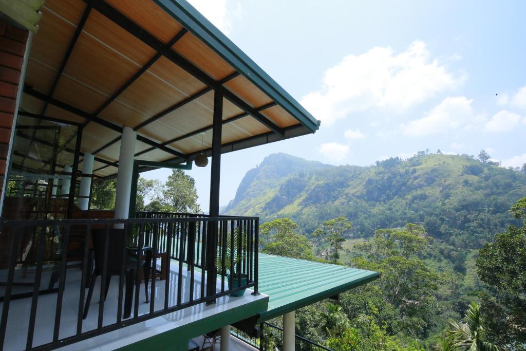 a balcony of a house with a view of the mountains at Rock side inn - Ella in Ella