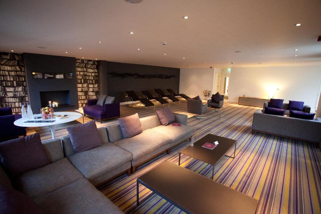 a living room with a couch and chairs and a fireplace at Lifehouse Spa And Hotel in Frinton-on-Sea
