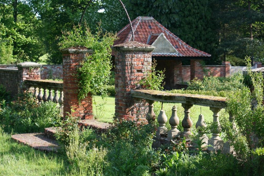 a brick fence in a garden with a house at Lifehouse Spa And Hotel in Frinton-on-Sea