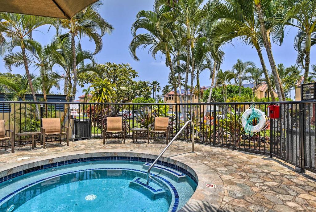 a swimming pool with a fence and palm trees at Kailua-Kona Condo with Resort Access and Ocean View! in Kailua-Kona