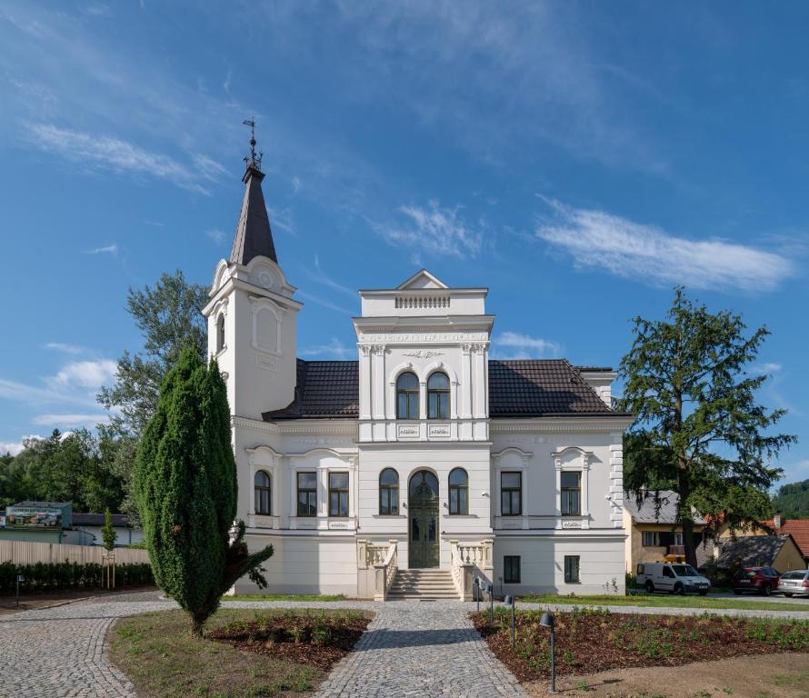 un grande edificio bianco con un campanile in cima di Villa Rosenaw a Rožnov pod Radhoštěm