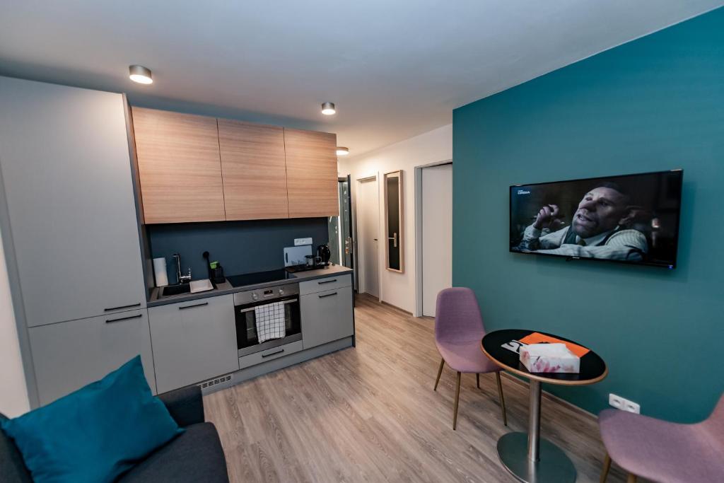 ein Wohnzimmer mit einem TV an einer blauen Wand in der Unterkunft Apartments 4u: KAMPUS Hradec Králové in Hradec Králové