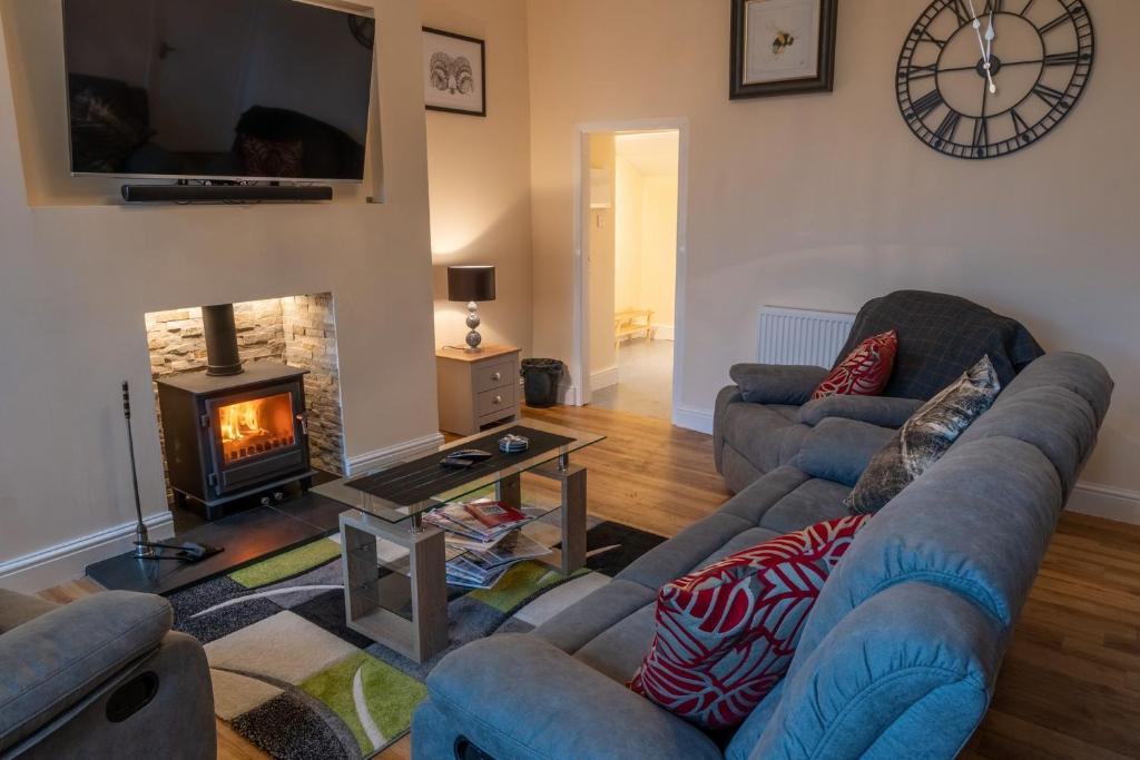 a living room with two couches and a fireplace at High Gregg Hall Farm Cottage in Underbarrow