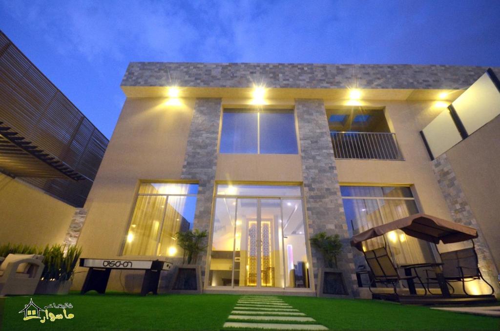 a large house with a lawn in front of it at Masurat Chalet in Riyadh