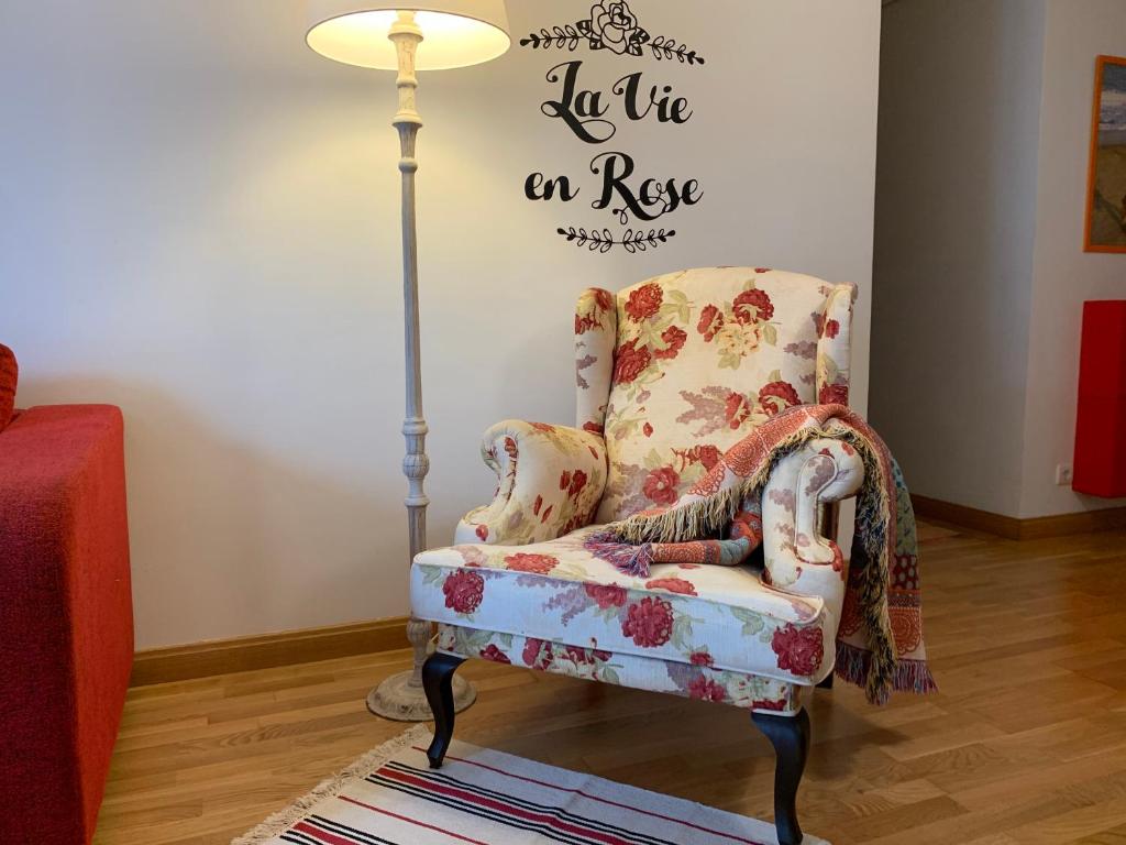 a living room with a chair and a lamp at La Vie en Rose Piso en el centro in Briviesca