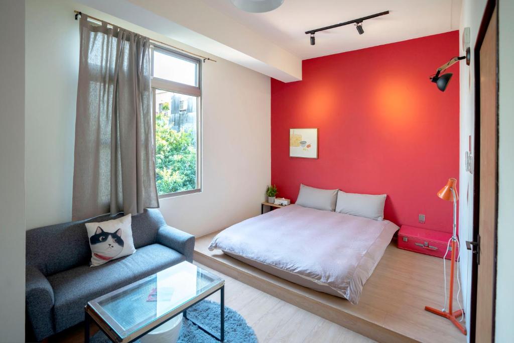 台南漫半拍 Lento Hostel 的小房间设有一张床和红色的墙壁