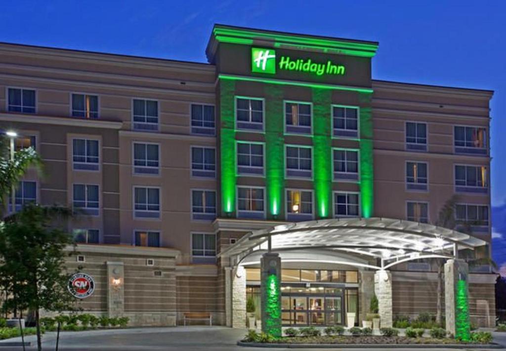 Un hotel con un edificio iluminado de color verde. en Holiday Inn Hou Energy Corridor Eldridge by IHG, en Houston