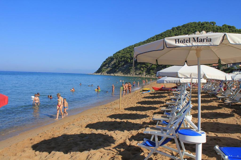 una spiaggia con un gruppo di persone in acqua di Hotel Maria a Castellabate