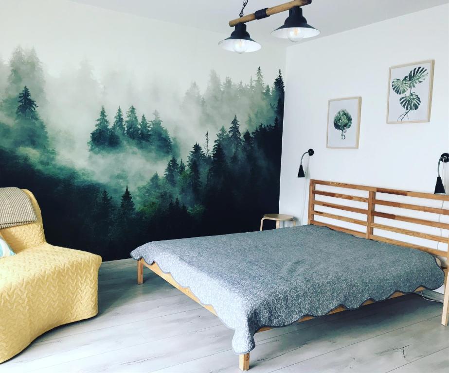 a bedroom with a forest mural on the wall at Bielski Zakątek bezobsługowy in Bielsko-Biała