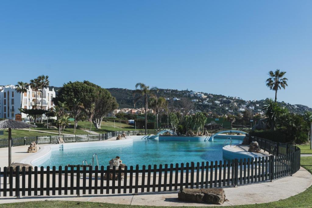 ein großer Pool in einem Park mit einem Zaun in der Unterkunft Apartamento Roller - a pie de playa in Zahara de los Atunes