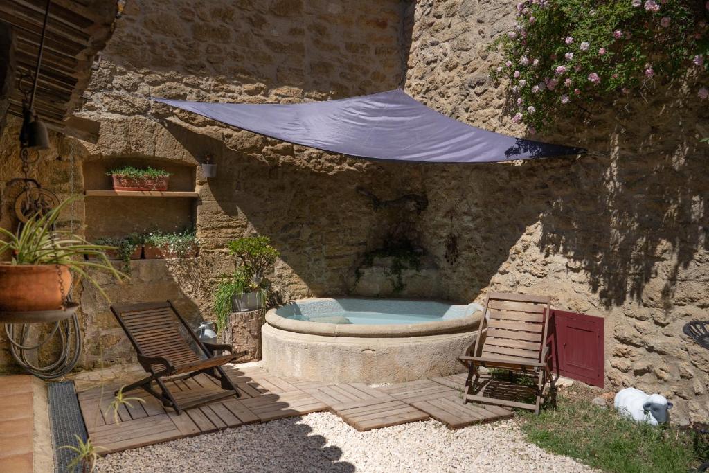 d'une terrasse avec une baignoire, 2 chaises et une tente. dans l'établissement Une Chambre en Luberon, à Puyvert