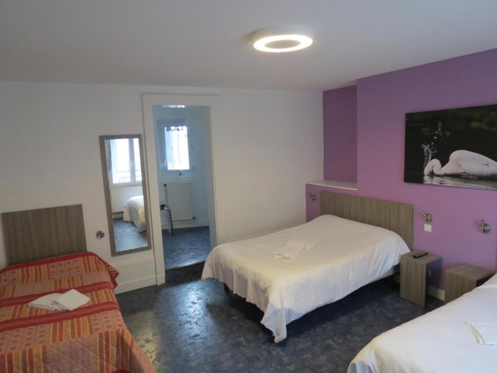 サン・タヴェルタンにあるHotel le Faisanのベッド2台と鏡が備わるホテルルームです。
