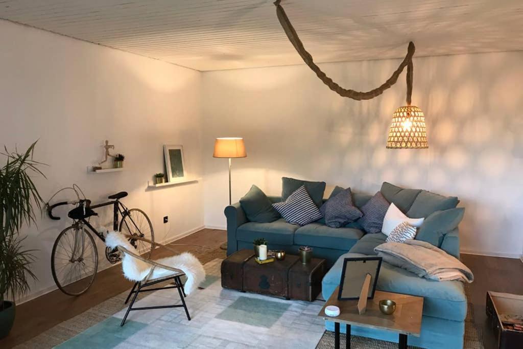 ein Wohnzimmer mit einem blauen Sofa und einem Fahrrad in der Unterkunft Sunset House - 130 qm Whg. - Vallendar / Koblenz in Vallendar