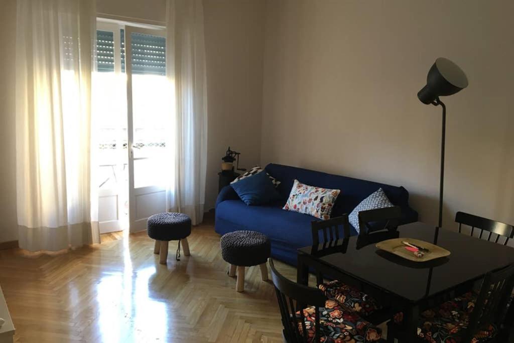 uma sala de estar com um sofá azul e uma mesa em Casa Dede em Sanremo