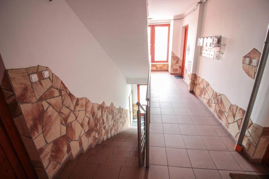 a hallway with a tile floor and a stone wall at Entire Home in Budapest