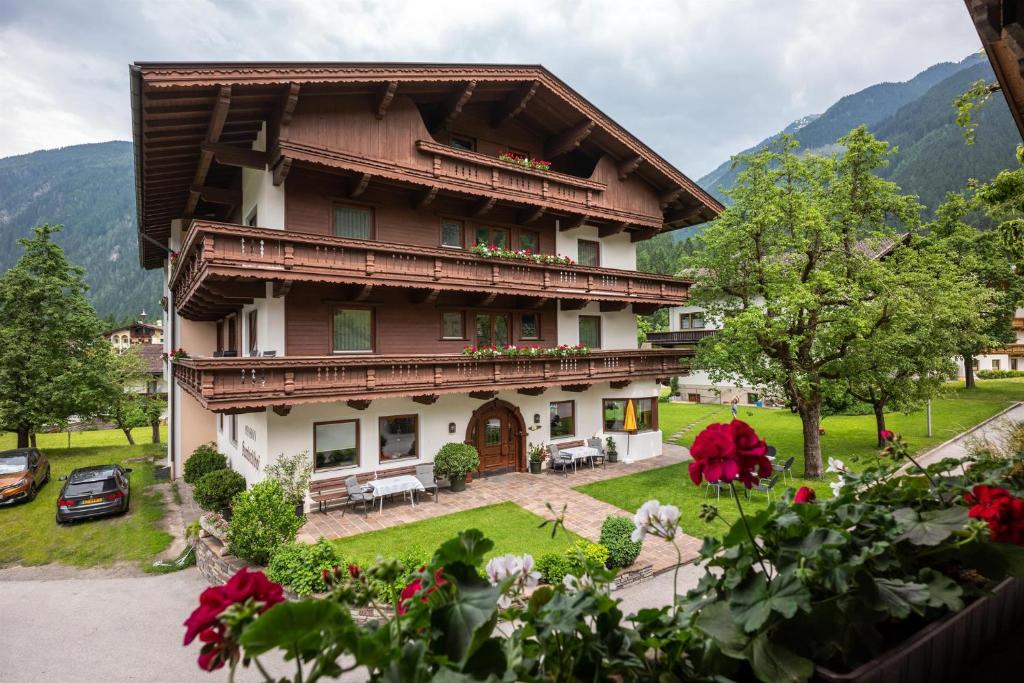a large house with a garden in front of it at Pension Kumbichlhof in Mayrhofen