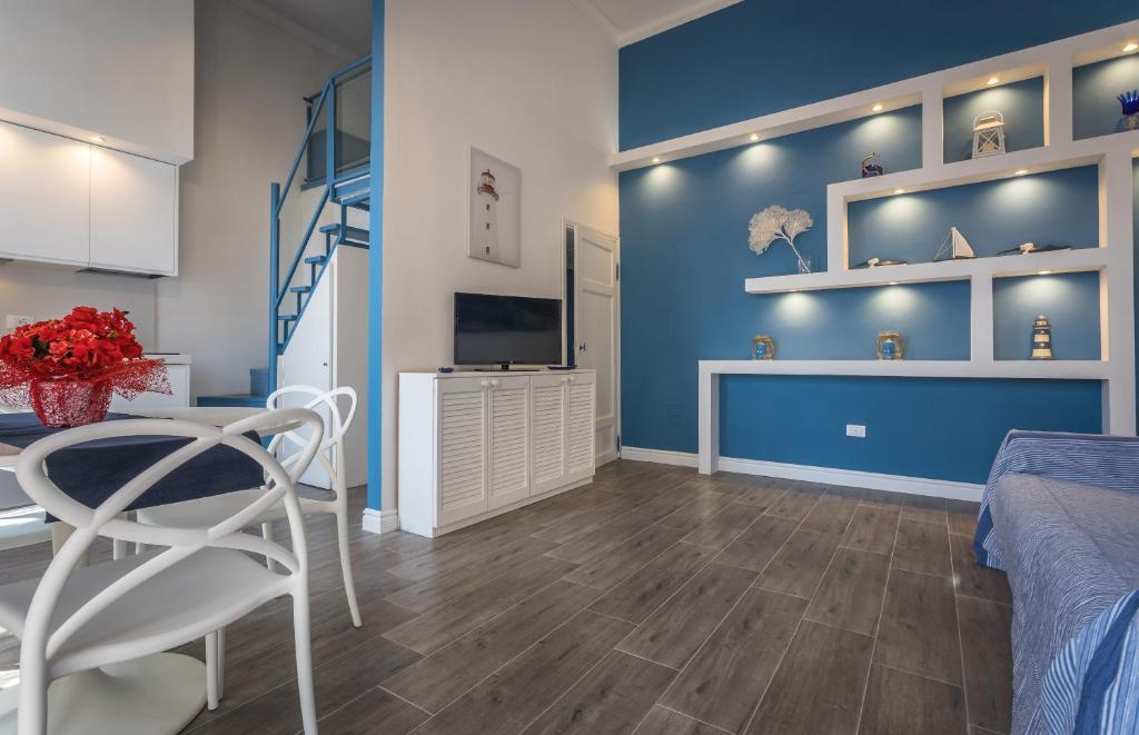 a bedroom with a blue wall and a bed and a table at Scricciolo in Viareggio