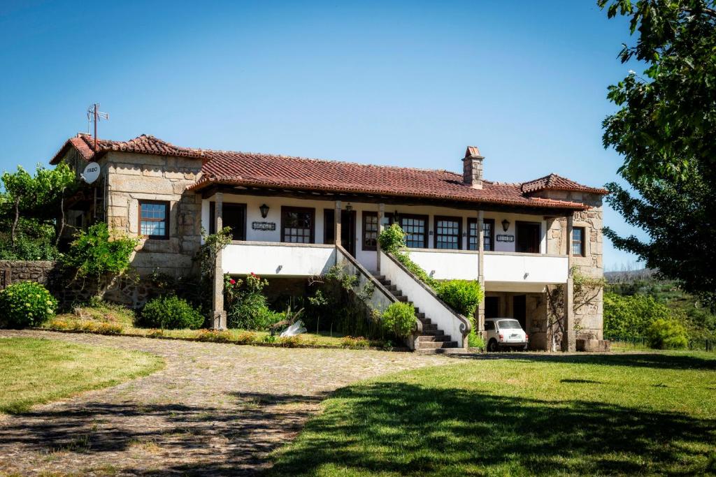 an old house with a car parked in front of it at Casa Da Quinta Do Rei in Ponte de Lima