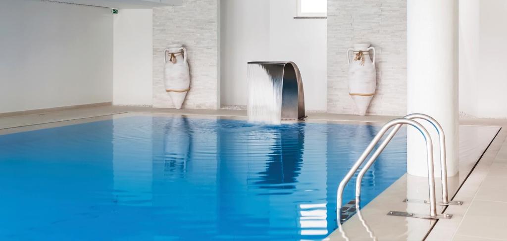 - une piscine d'eau bleue avec un robinet dans l'établissement MH Peniche, à Peniche