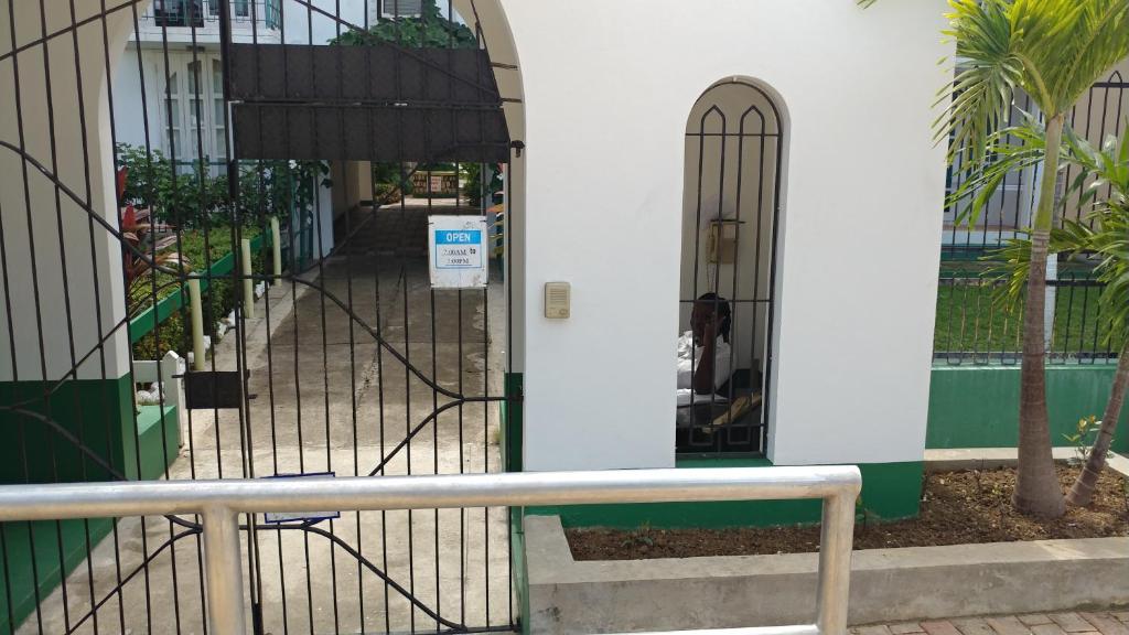 une porte menant à un bâtiment avec un chien. dans l'établissement SandCastles Holiday #C9, à Ocho Rios
