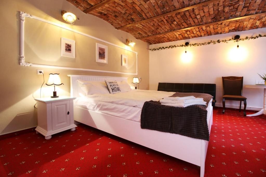 a bedroom with a large white bed with a red carpet at Brother's House in Sibiu