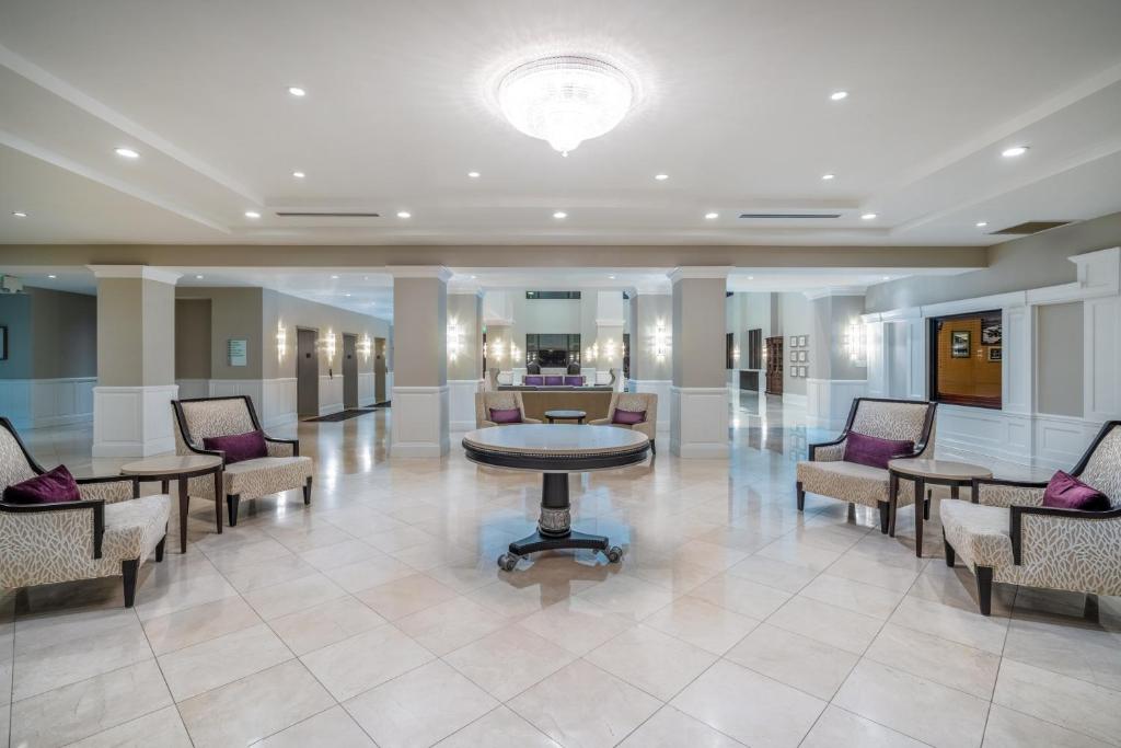a lobby with chairs and a table in a building at Holiday Inn Wilmington by IHG in Gurneyville