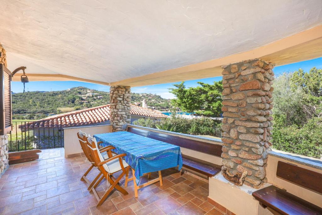 a dining room with a table and chairs on a balcony at Corbezzoli in San Teodoro