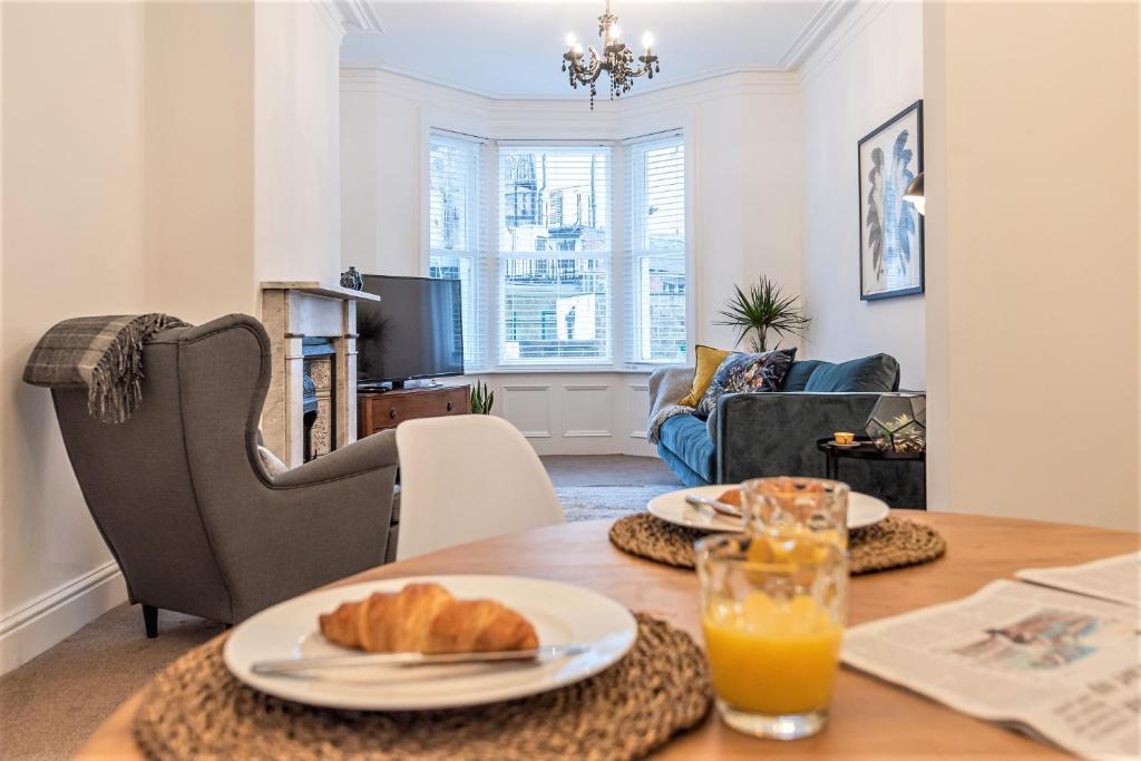 einen Tisch mit einem Teller Croissants darauf im Wohnzimmer in der Unterkunft Perfectly Located 4 Storey Townhouse With 2 Parking Spaces In Central Harrogate in Harrogate