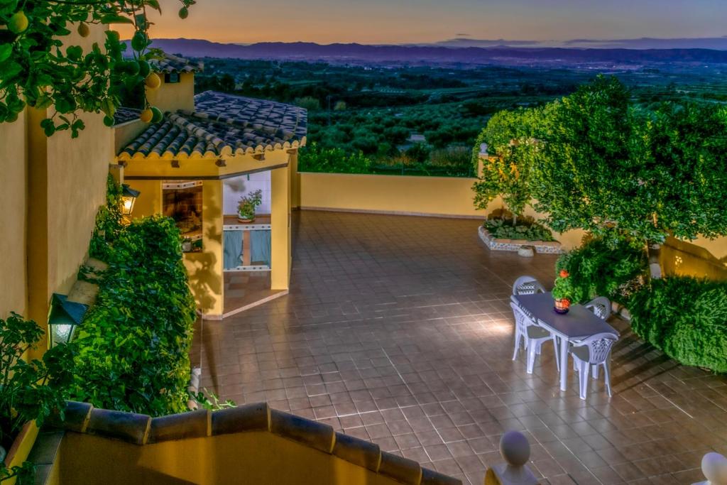 - une vue sur une maison avec une table et des chaises dans l'établissement Terra Blanca del Benicadell, à Beniatjar